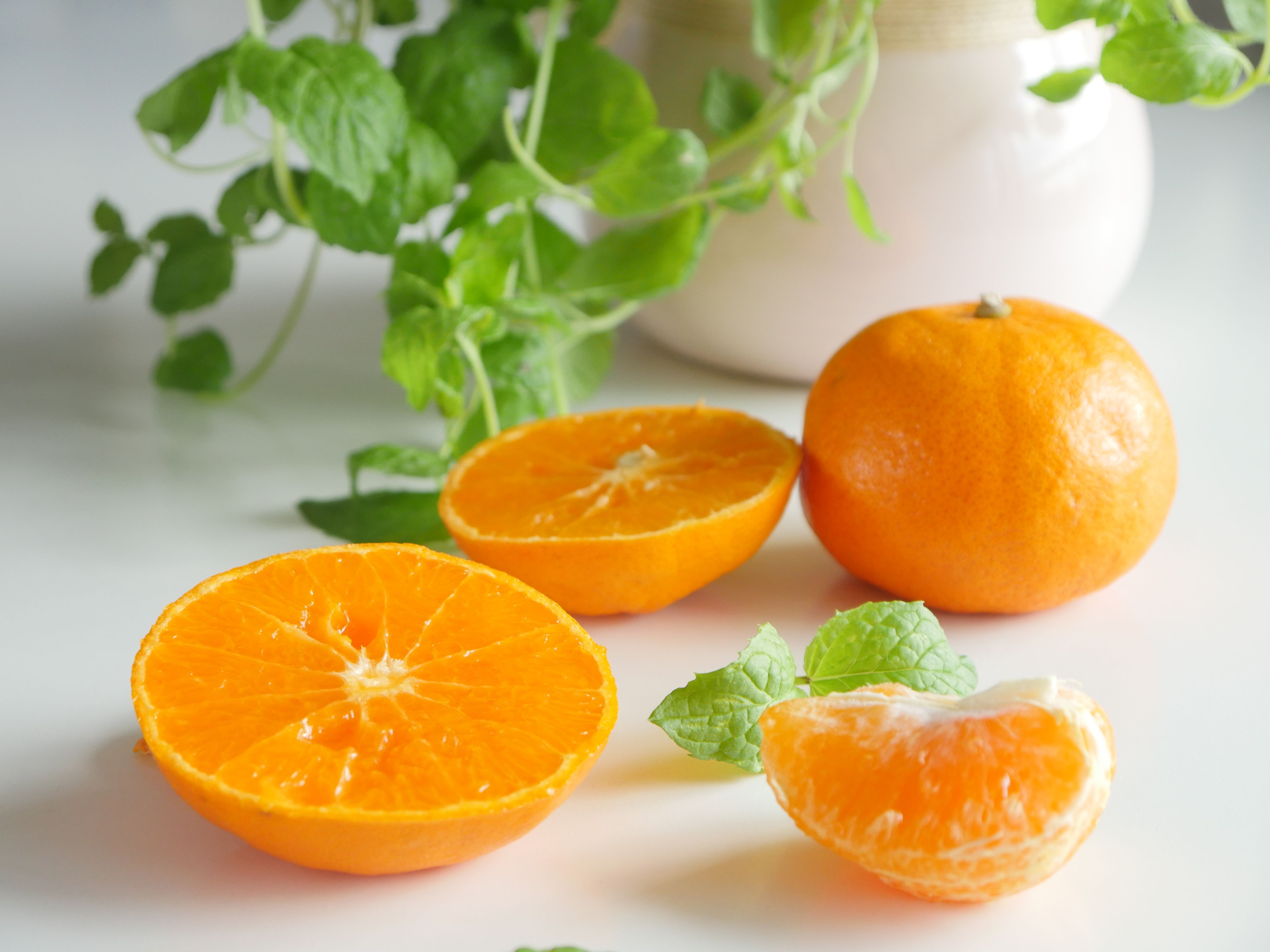 Close-Up Shot of Fresh Orange Fruits on White Surface · Free Stock Photo