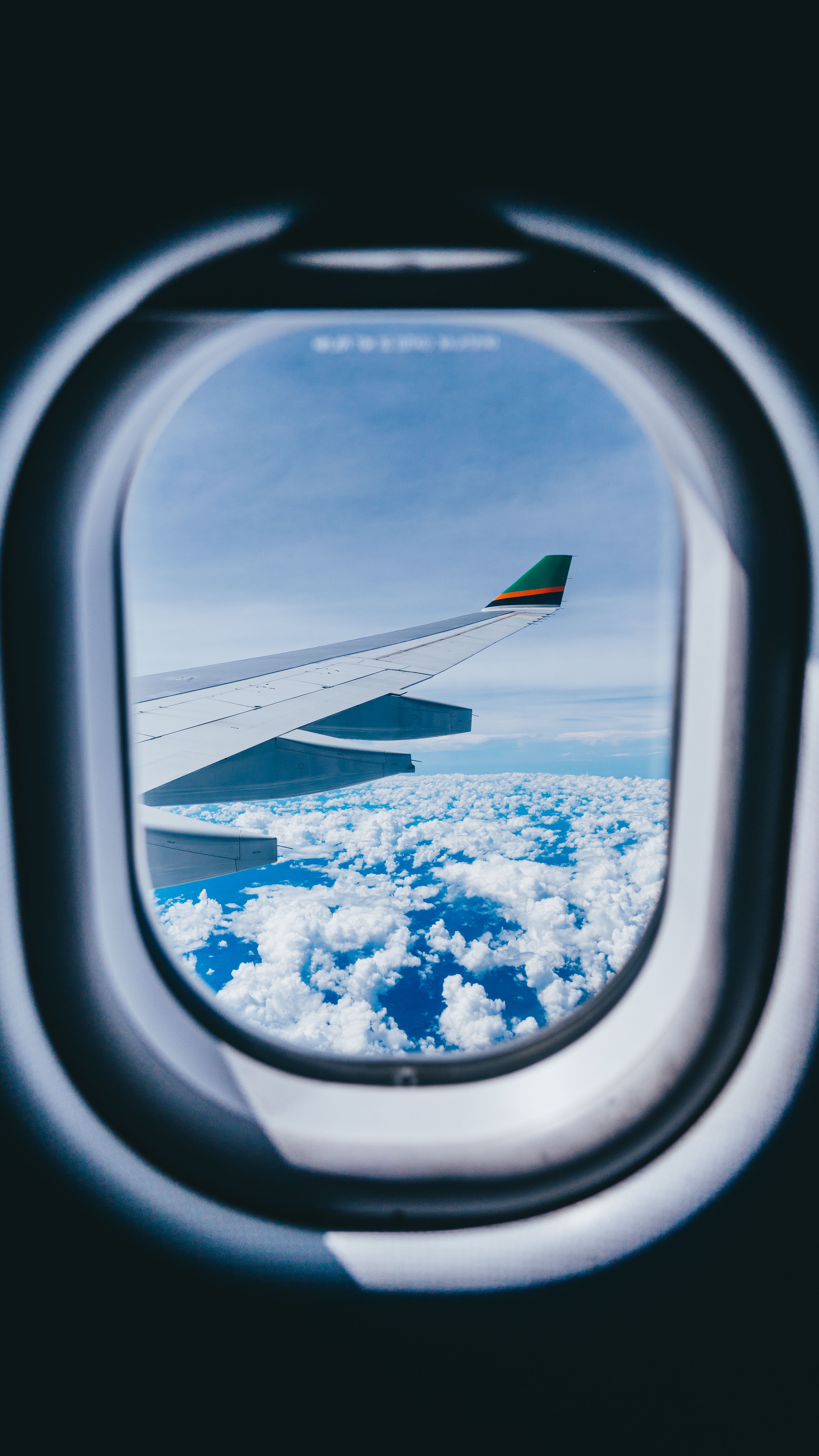 Airplane Window View of Airplane Wing and Clouds · Free Stock Photo
